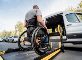 Two older adults walking outdoors with mobility walkers